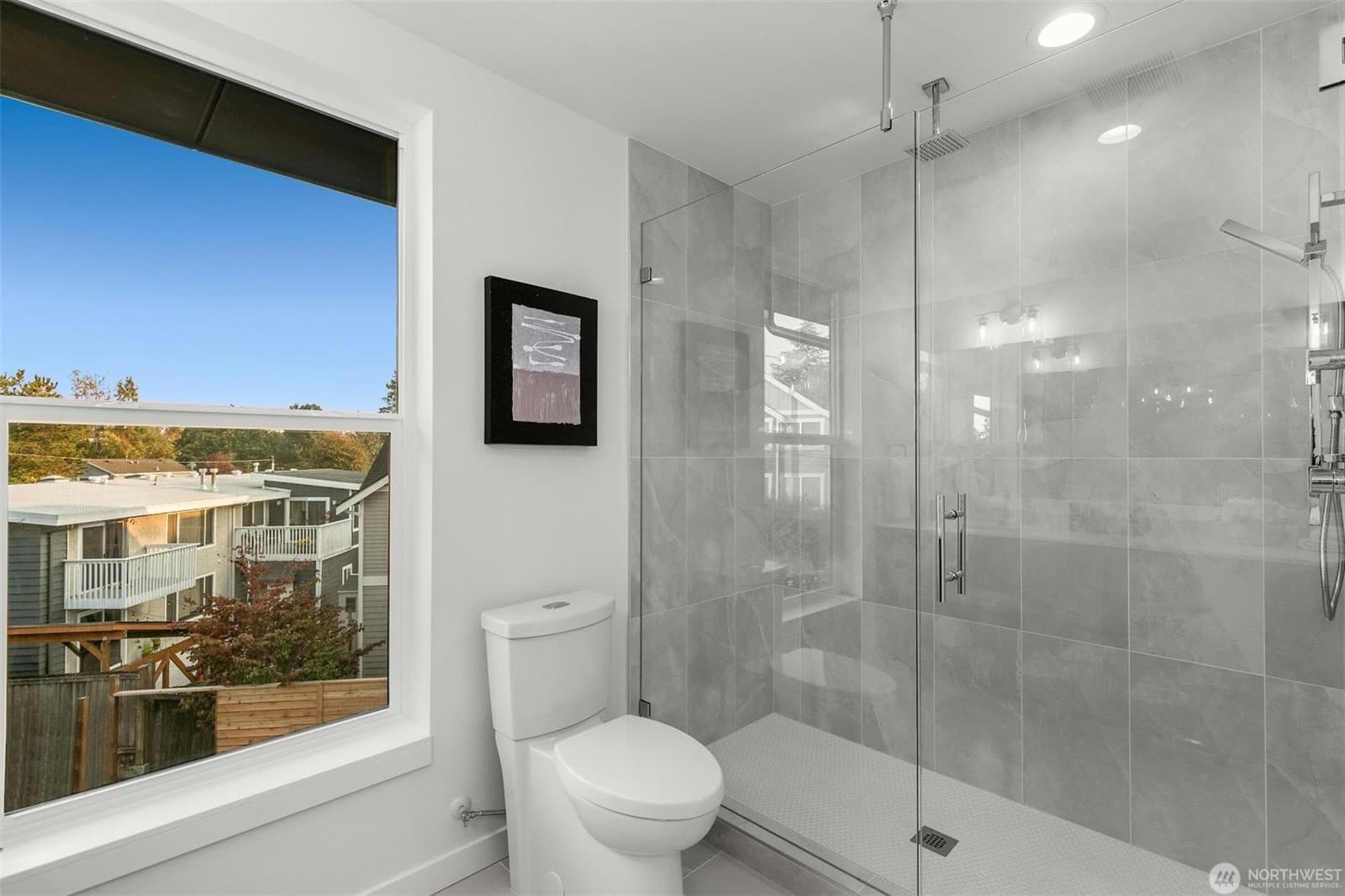 Bathroom with a walk-in glass shower and a window at the vanity