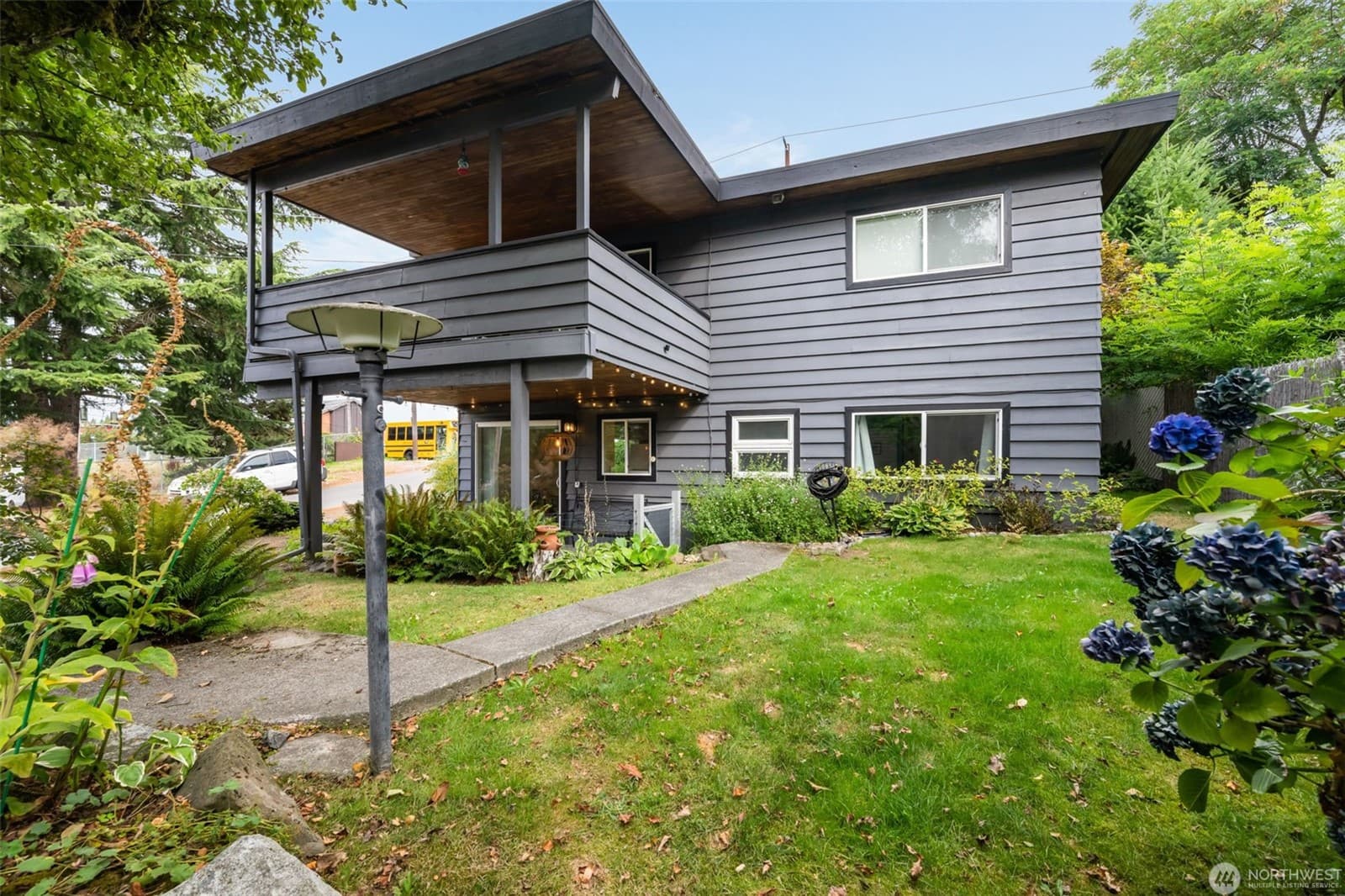 The duplex from the side, its cantilevered upper level projecting over the entry