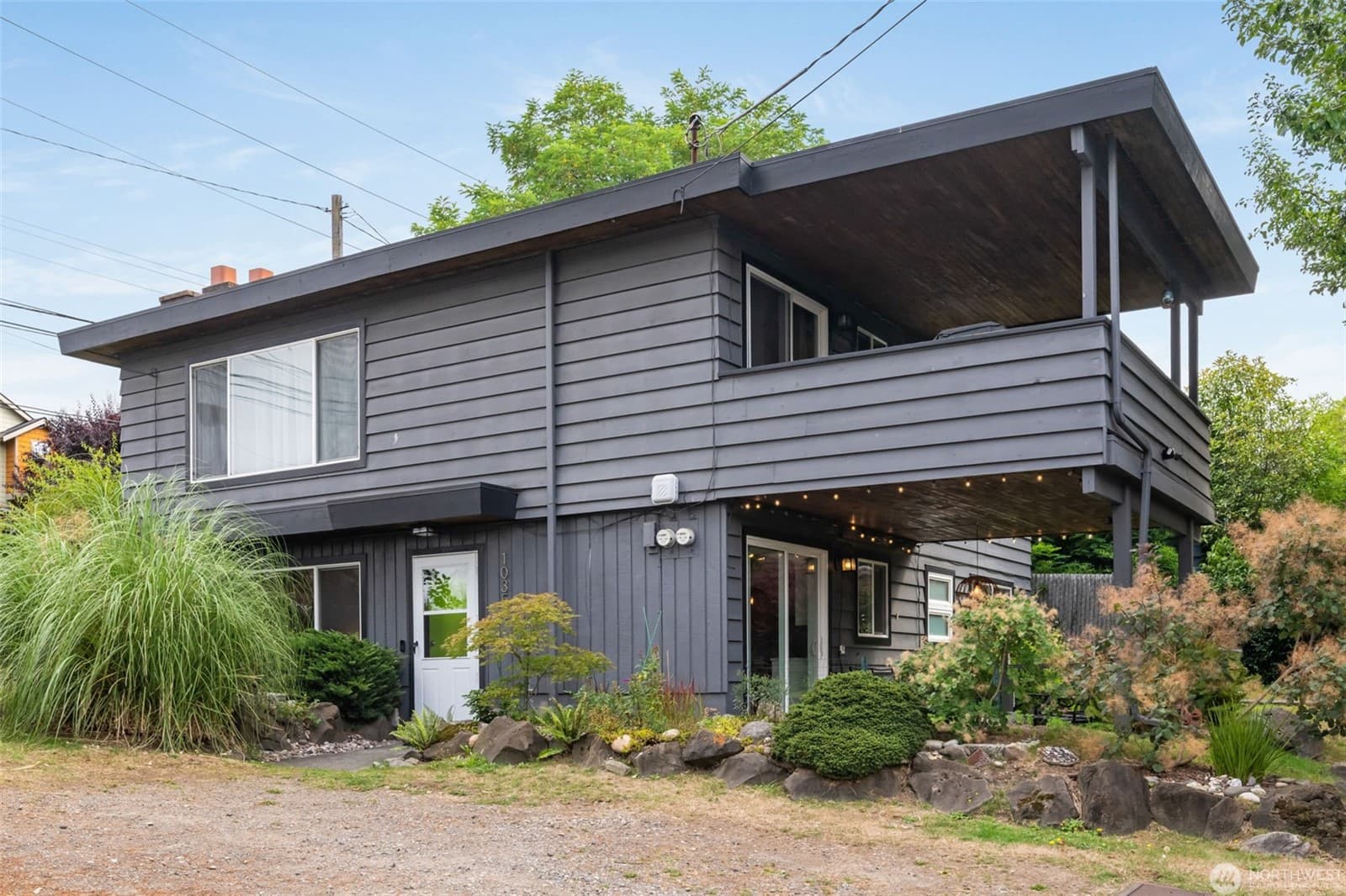 Front elevation of the duplex, with the upper unit's balcony above the lower entry