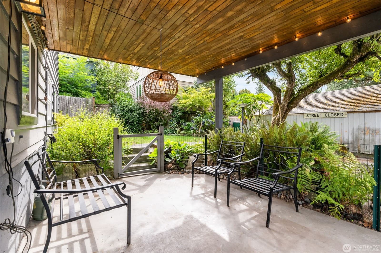 Covered patio under a wood ceiling, strung with lights