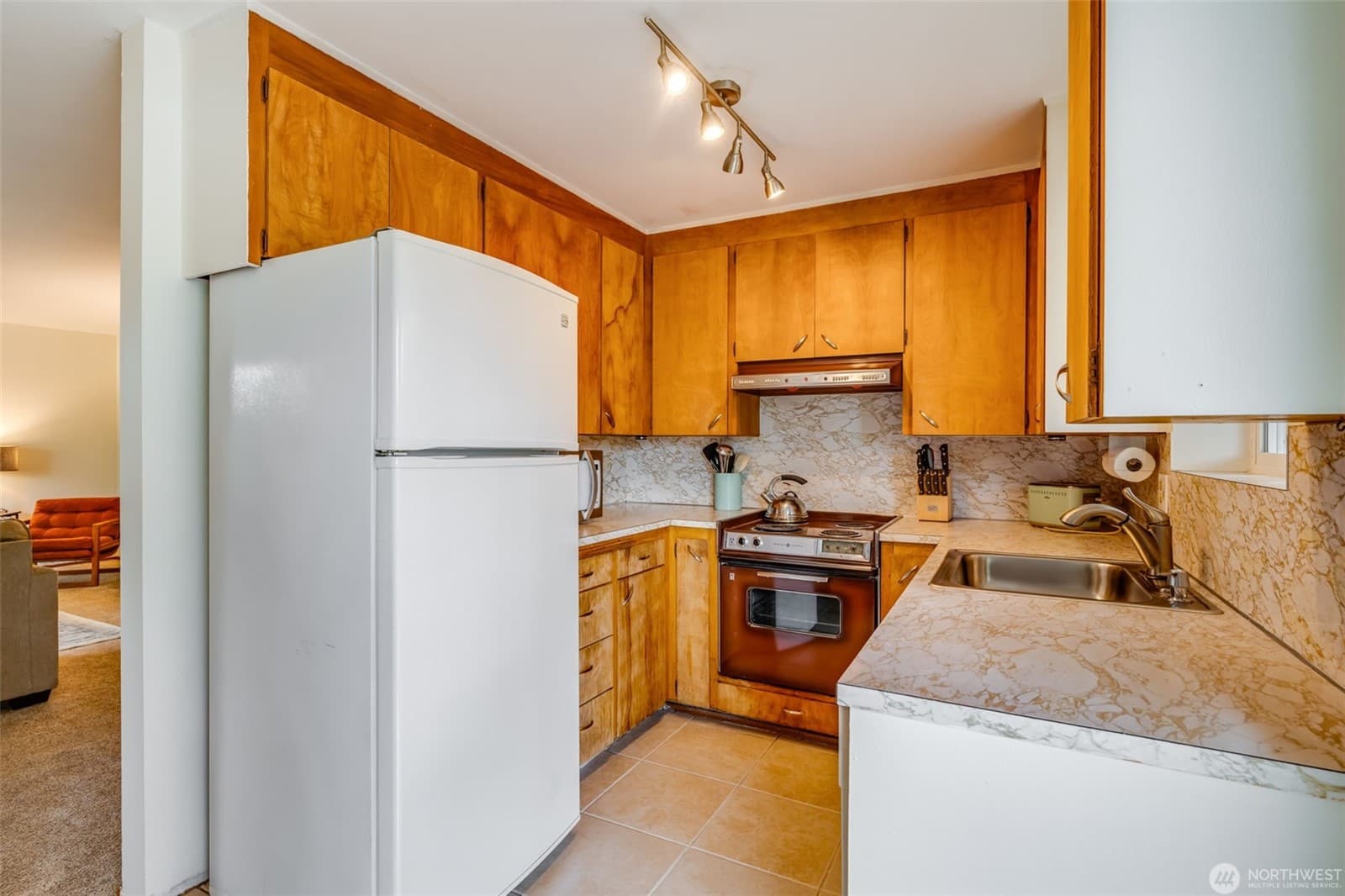 Kitchen with wood cabinetry and tiled counters