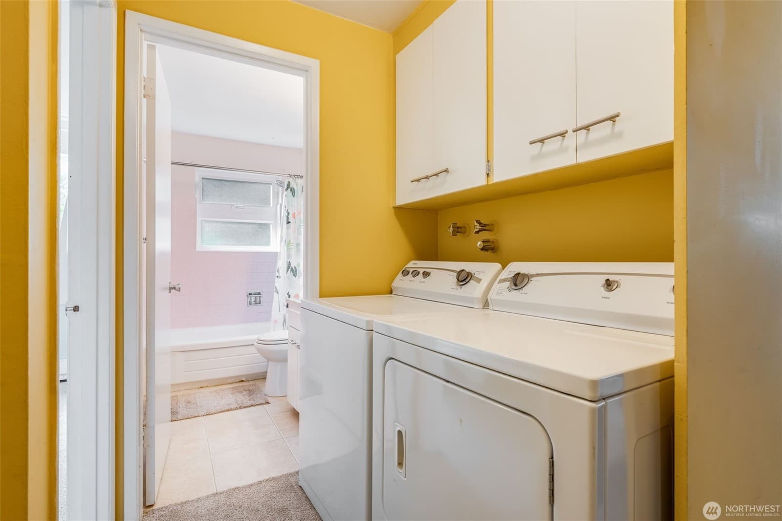 Laundry with full-size machines, opening through to the bathroom