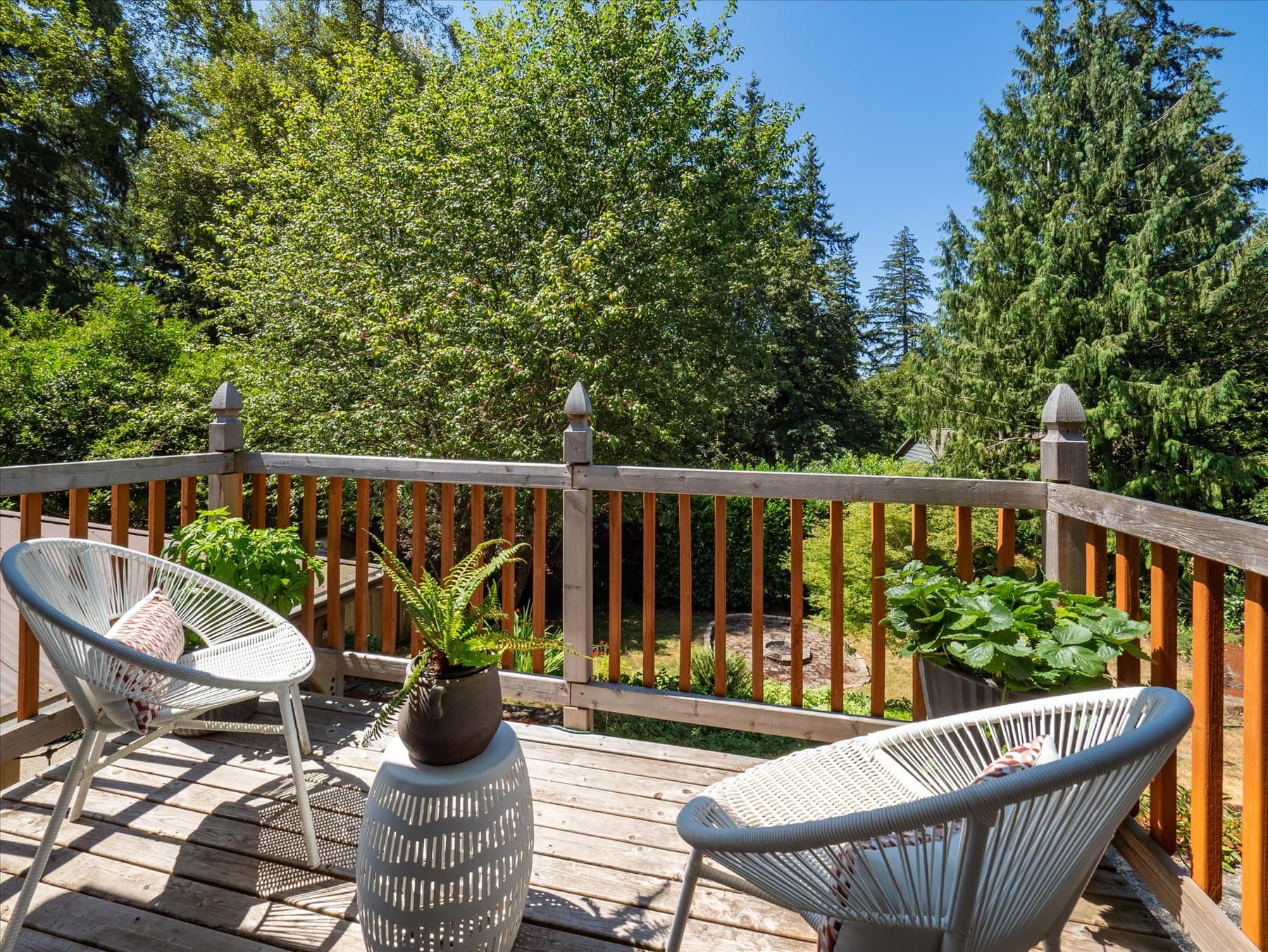 Rear deck with seating, looking out into the firs behind the house