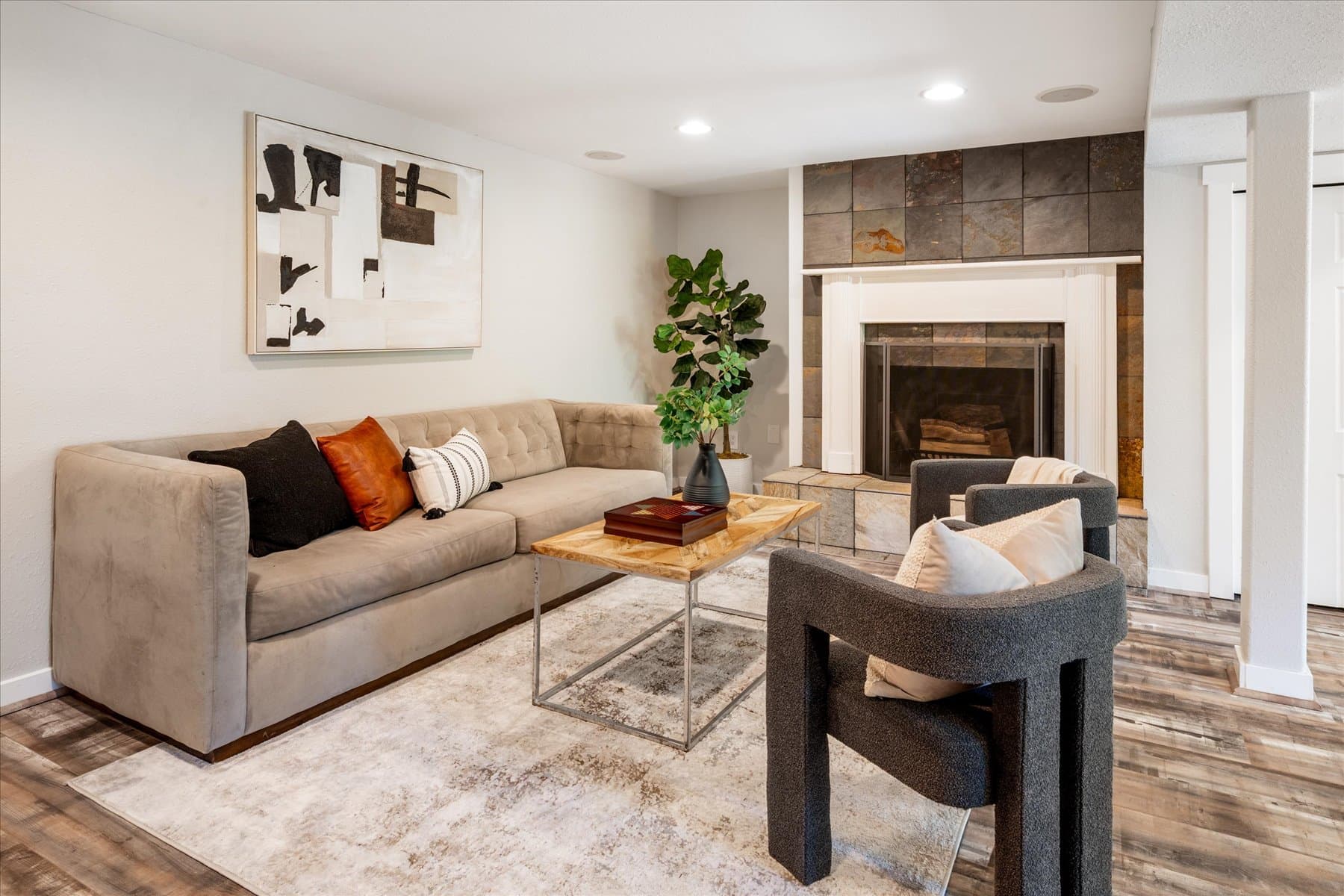 Lower-level family room with a tiled fireplace and sectional seating