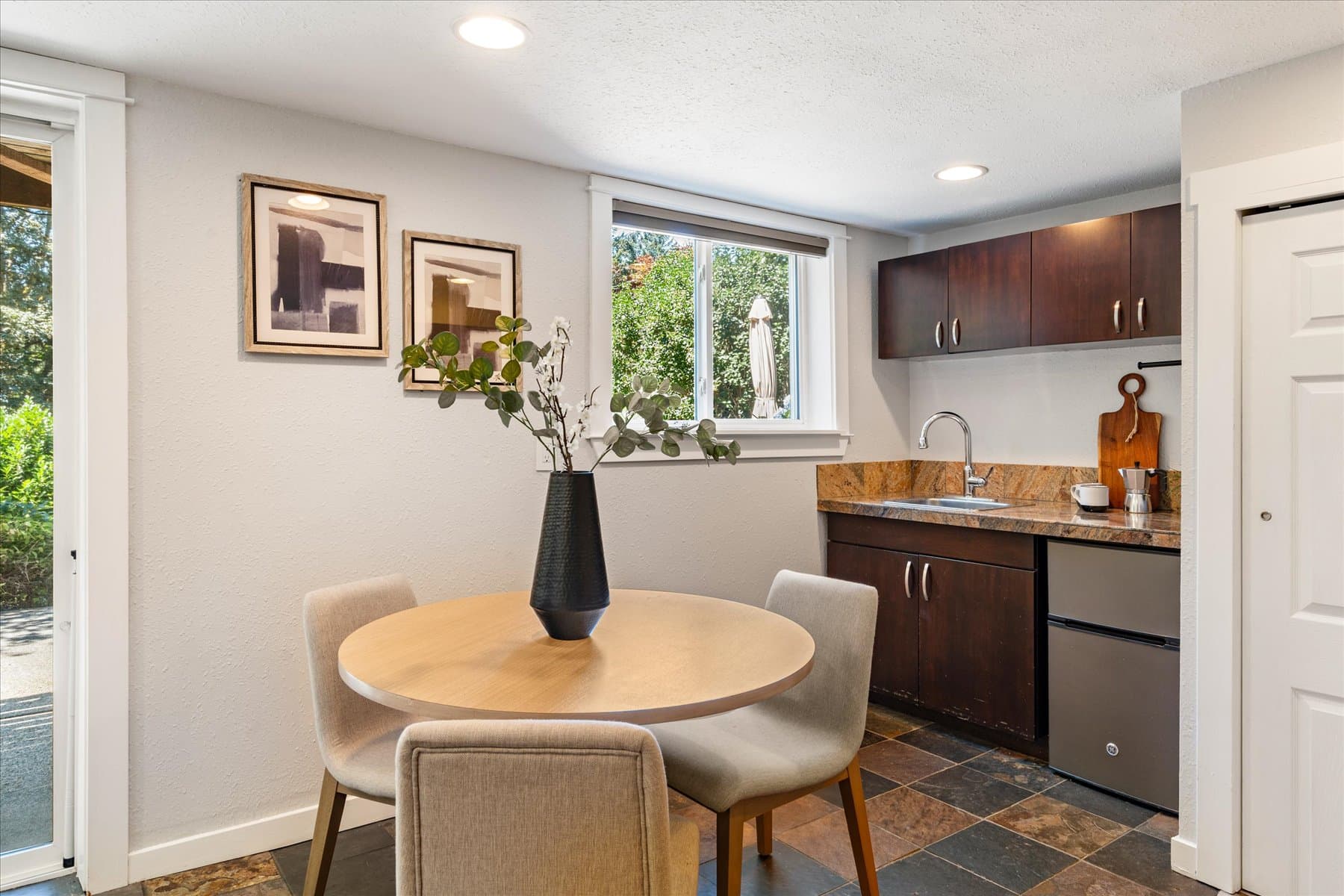 Lower-level kitchenette with a dining table and a window over the counter