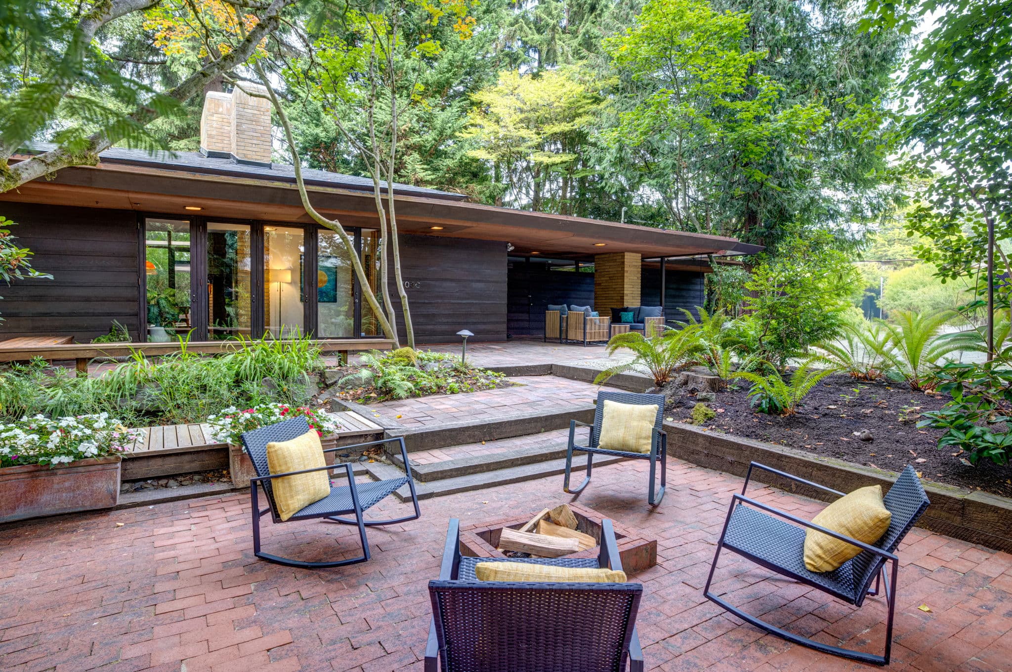 Brick terrace with a firepit and seating, the house behind