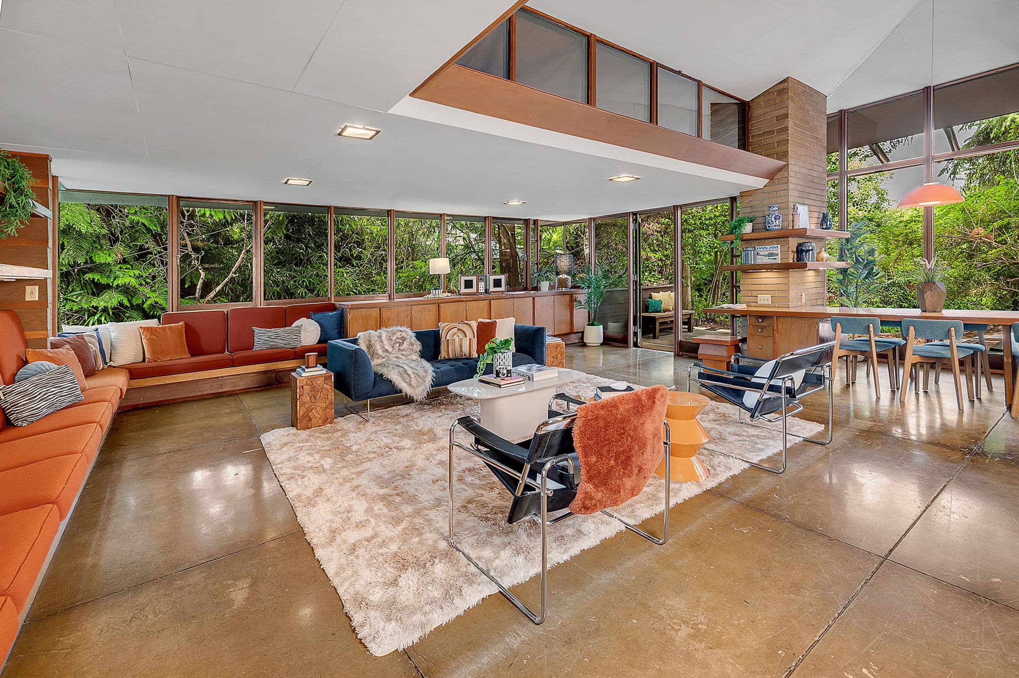 Living room under a clerestory, with a wall of glass onto the woods