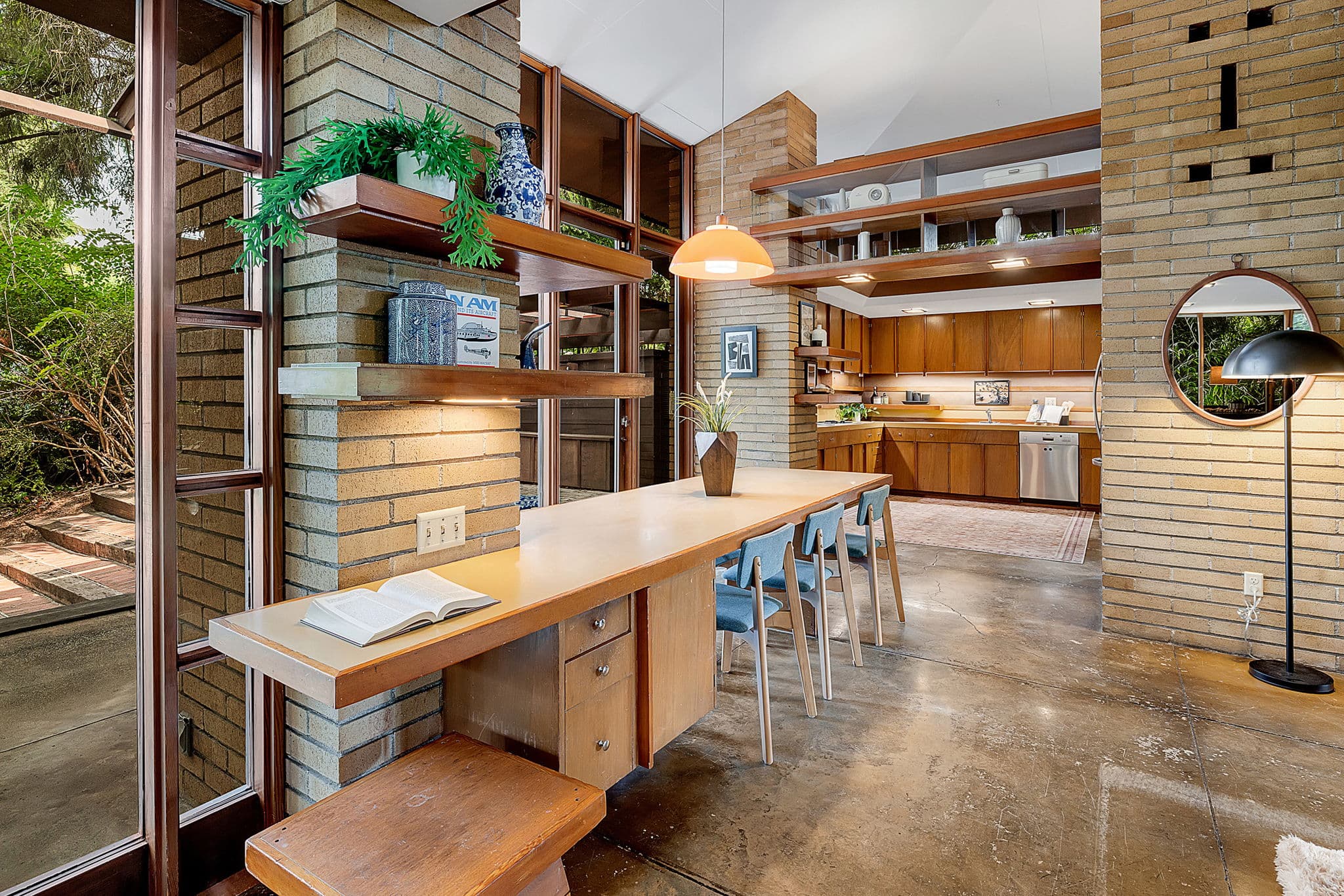 Long built-in desk with stools, under shelving and clerestory glass
