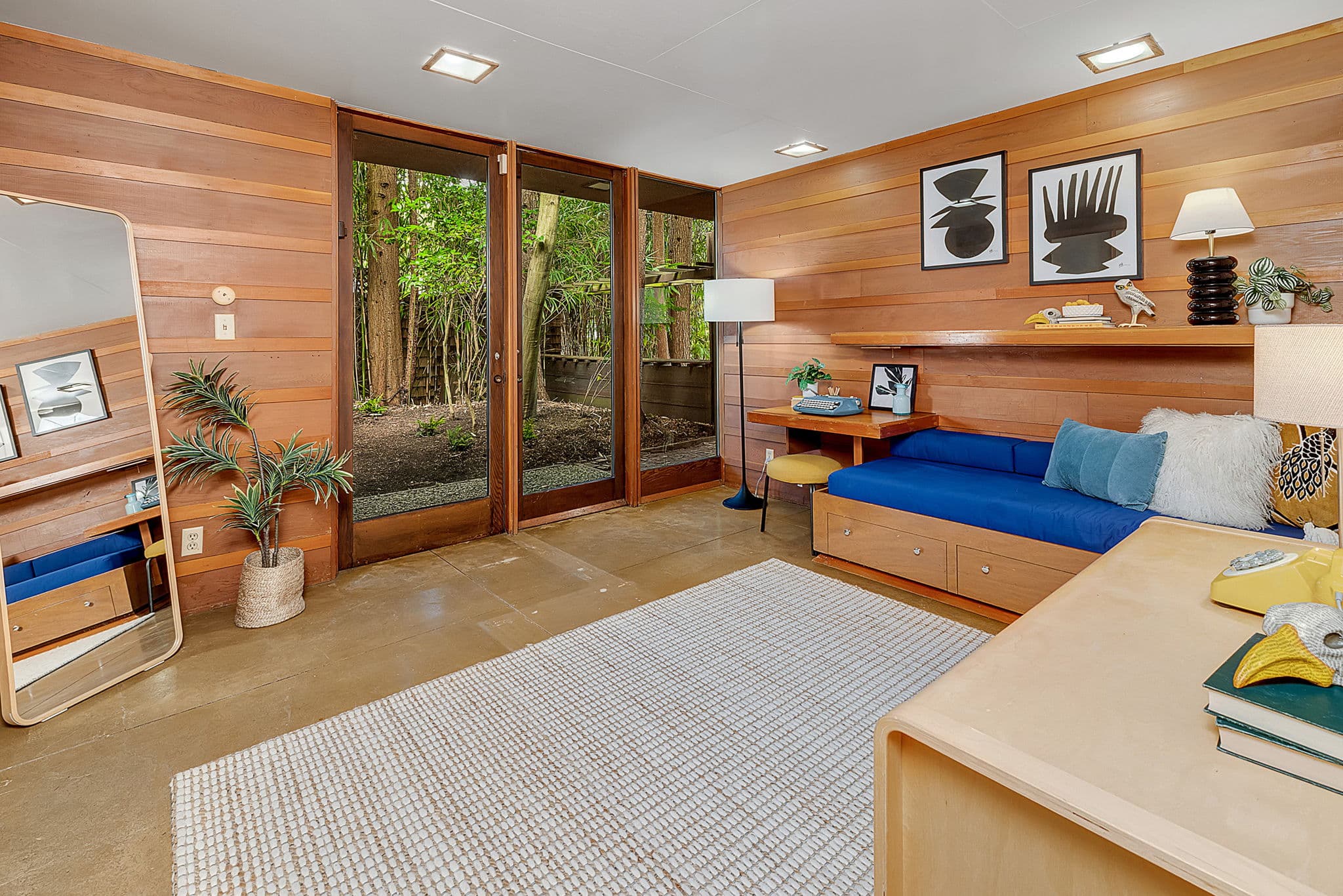Bedroom with a daybed under windows onto the trees