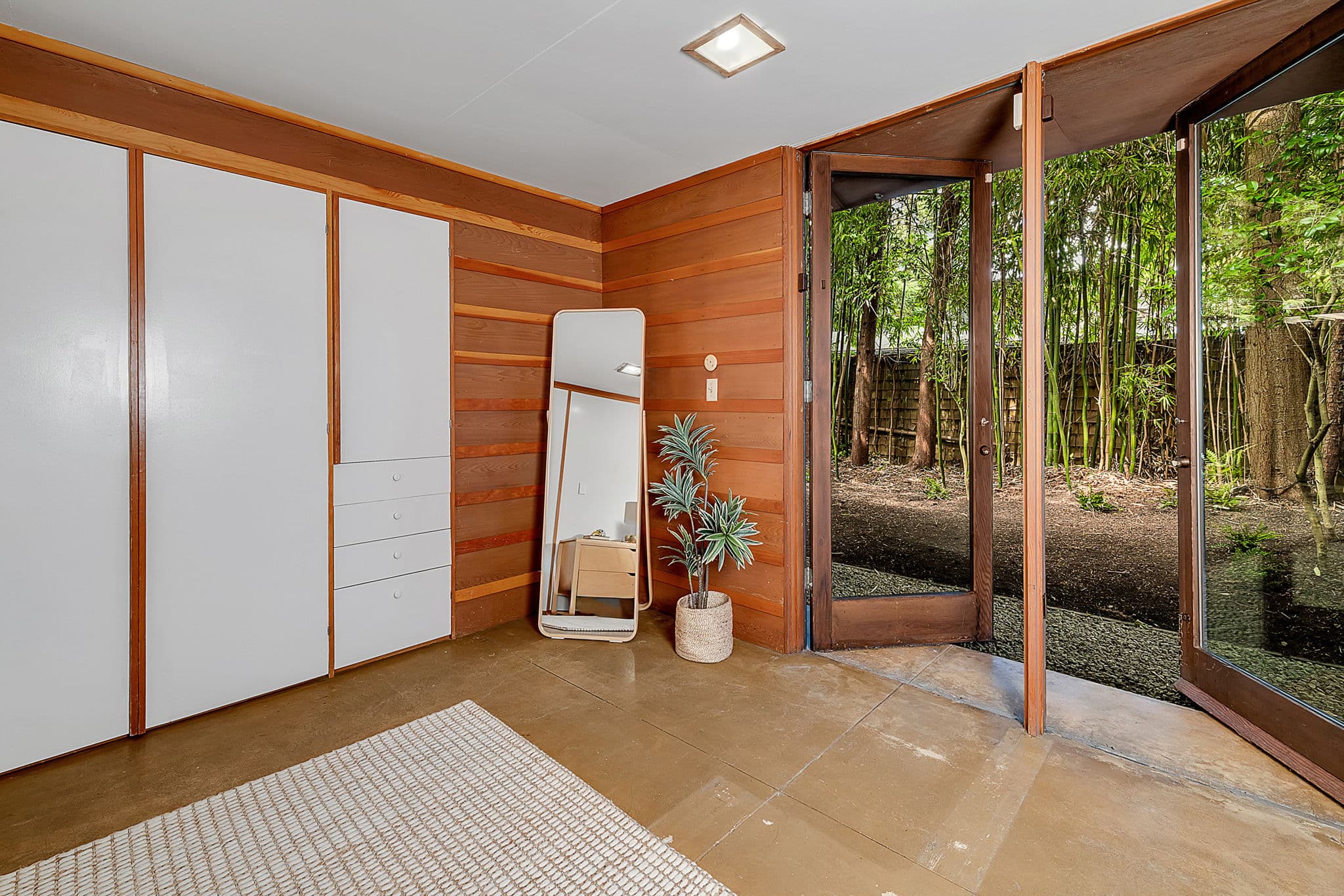Room with sliding closet doors and a glass door out to the woods