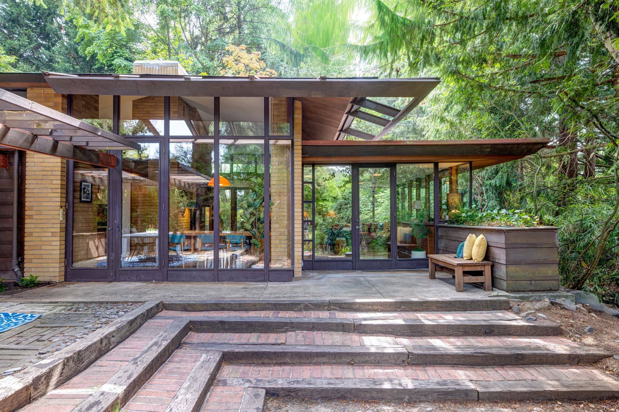 The house from the garden, glass walls under deep overhangs