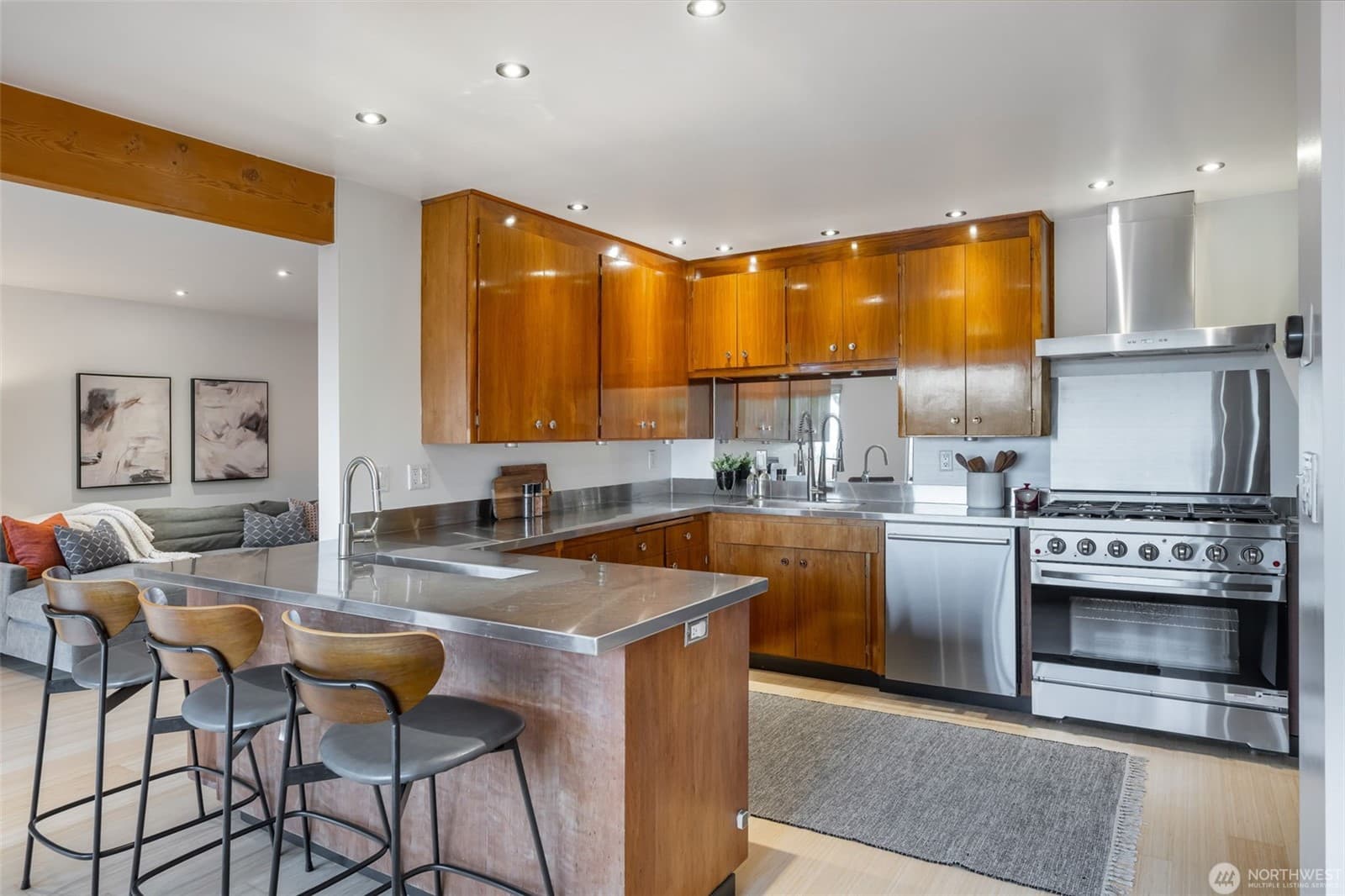 Kitchen with warm wood cabinetry, stainless counters and a professional range
