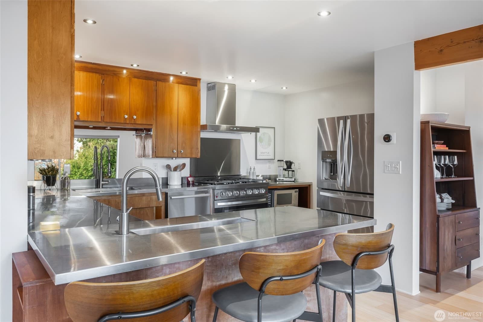 Kitchen straight on, with bar seating along the stainless island