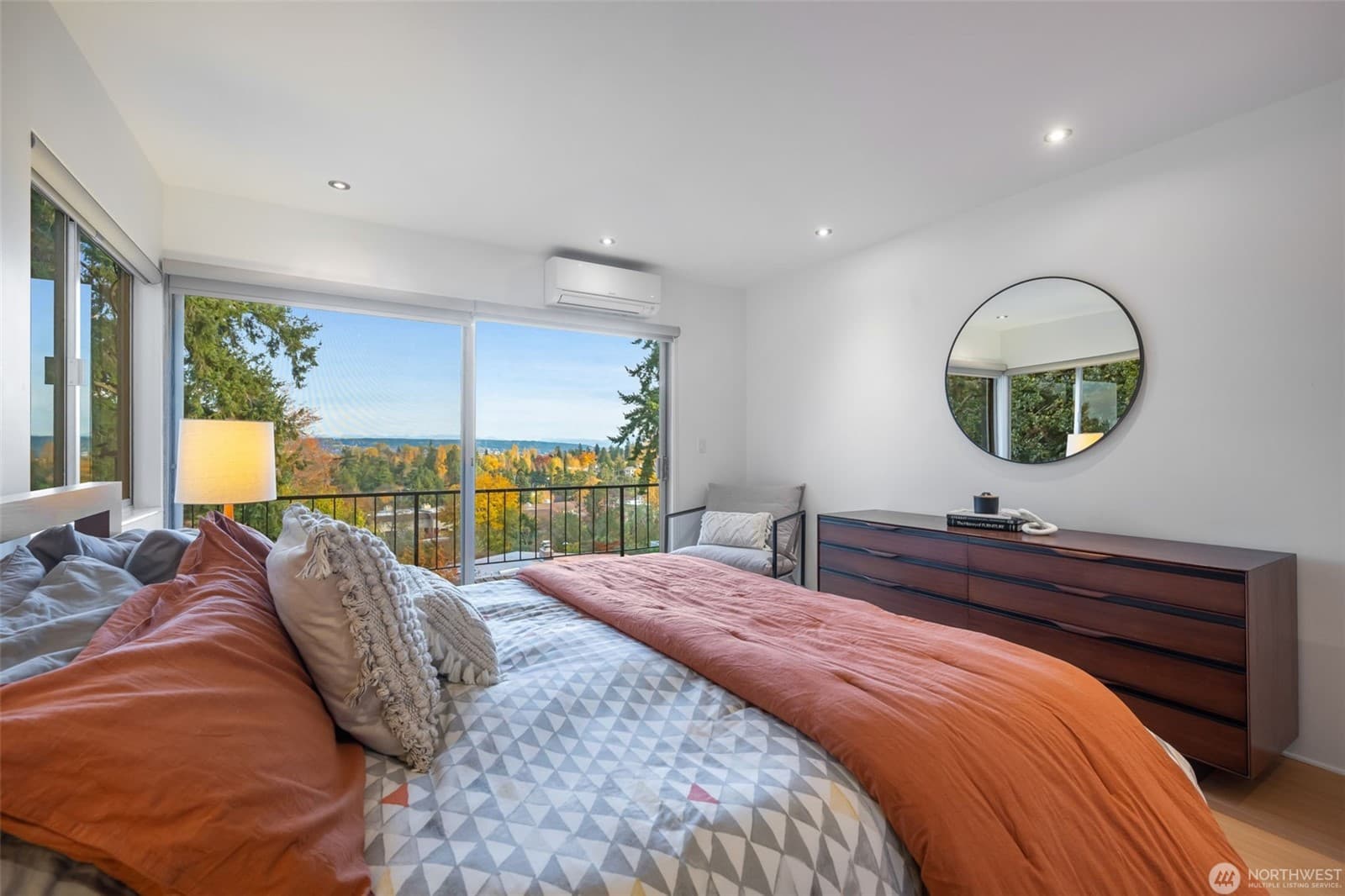 Bedroom with glass on two sides and a view out over the treetops
