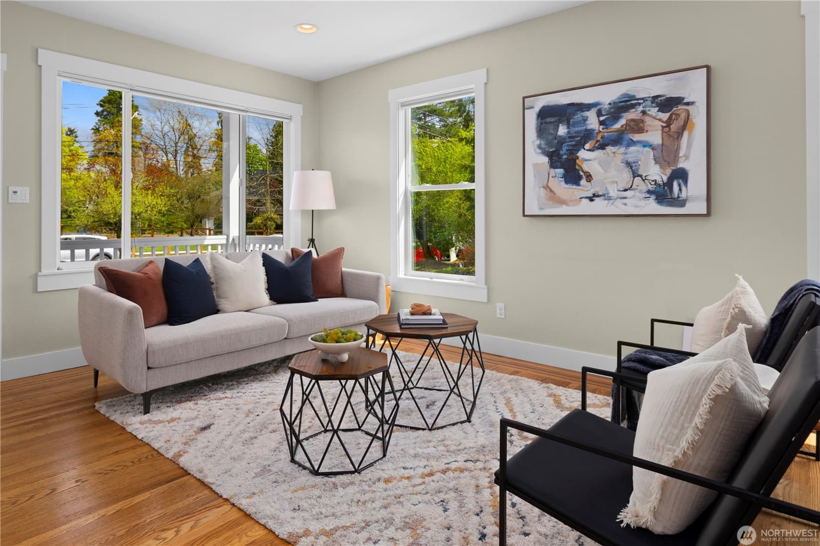 Living room seating area with corner windows over the yard