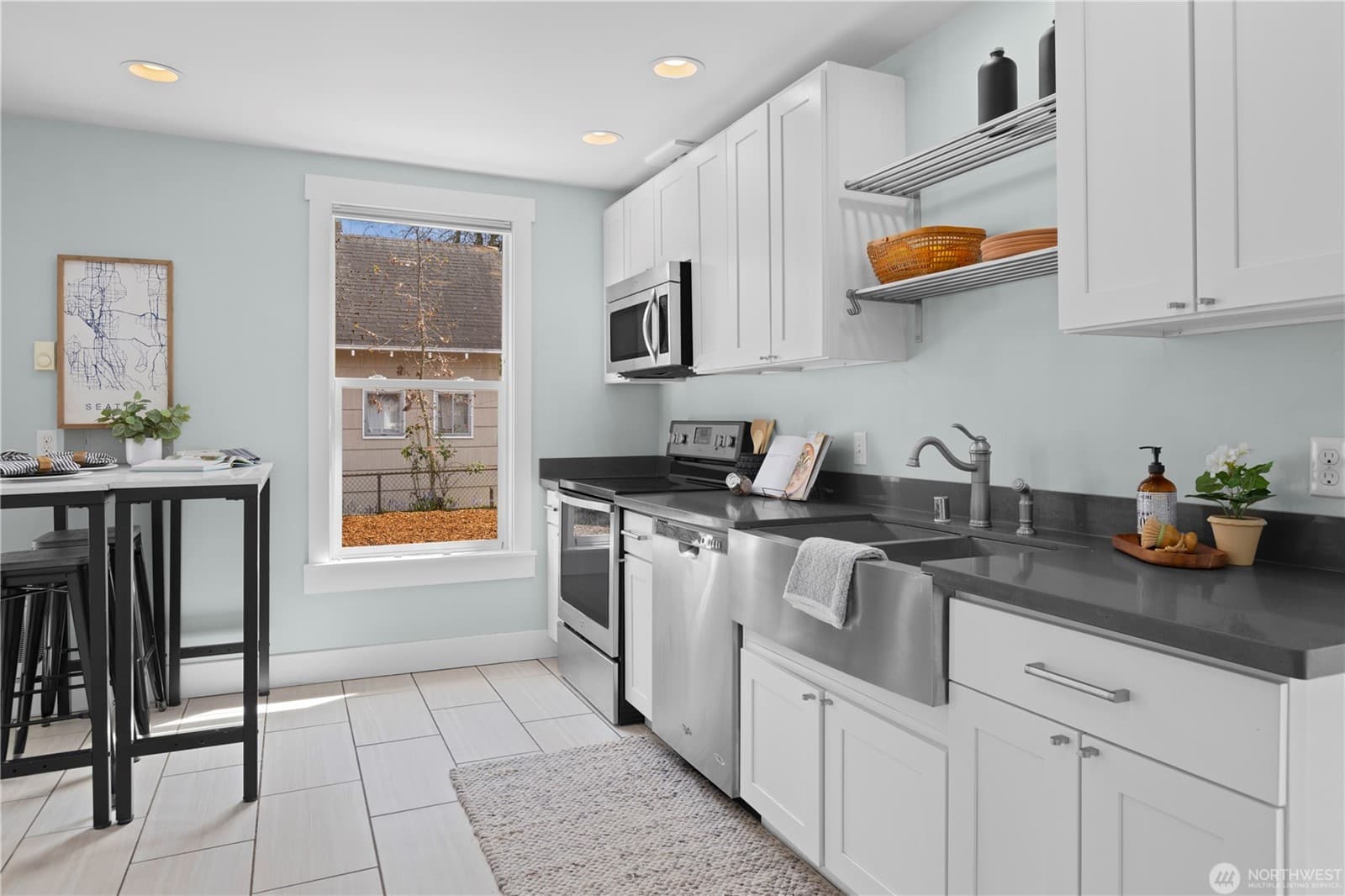 Kitchen from the far side, with the range, sink and a window over the counter