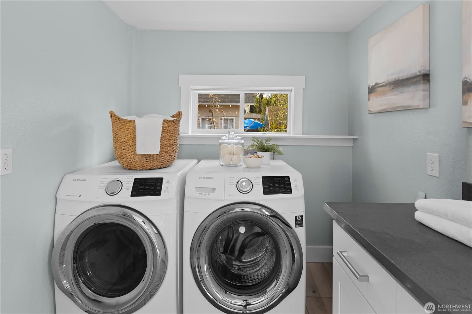 Laundry with full-size washer and dryer and a window over the counter