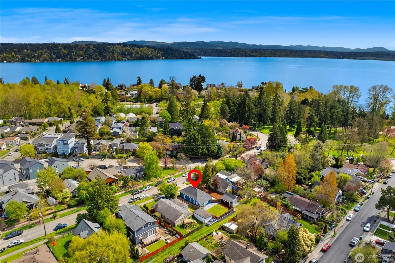 Aerial over the neighborhood with Lake Washington beyond, the house marked at centre